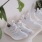 Lifestyle image of a row of white sneakers