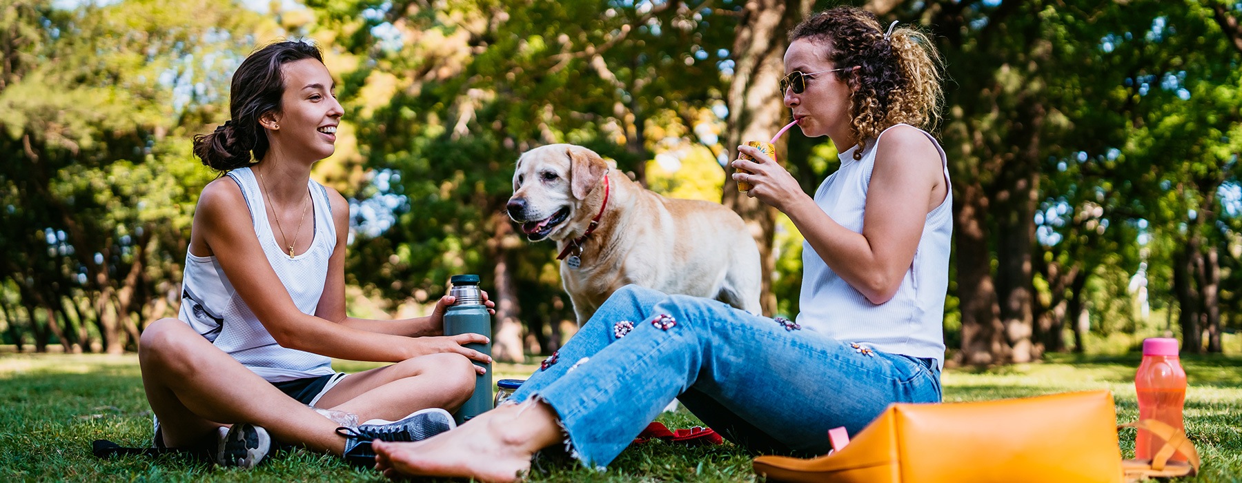 lifestyle image of two women and their dog outdoors